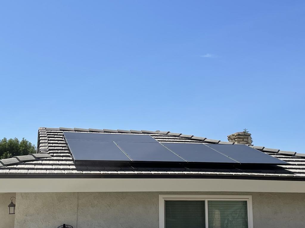 various solar panels installed on roof with blue sky background