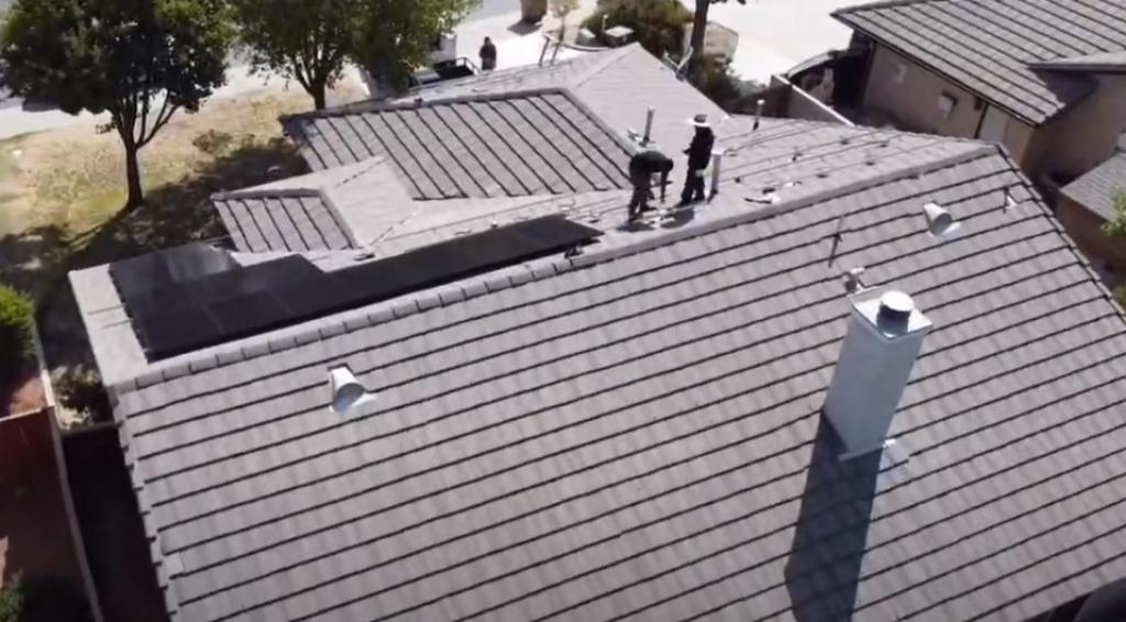 technicians installing solar panels on a roof